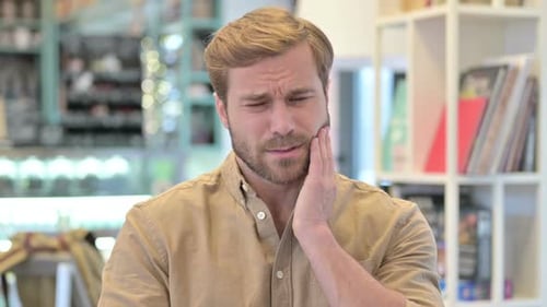 Portrait of Young Man Having Toothache Pain in Tooth