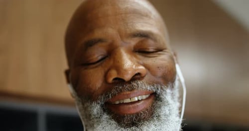 Senior Man Smiling with Earbuds Close-Up