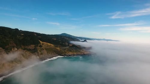 AERIAL: High above a foggy Oregon ocean, our drone pushes towards the coastline.
