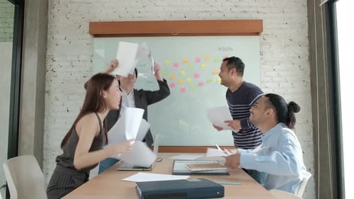 Asian office team celebrates success of the company's business.