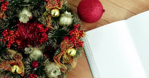 Close-up of coffee cup with christmas decoration and notebook