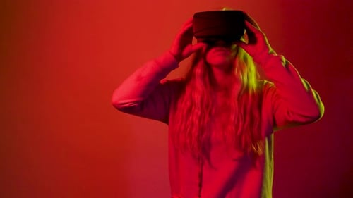 Studio shot isolated caucasian woman on res background using vr glasses wearing futuristic headset
