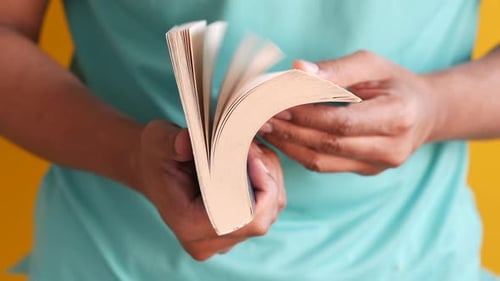 Close Up of Man's Hand Turning a Pager of a Book