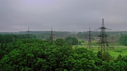 High voltage electricity towers among nature.