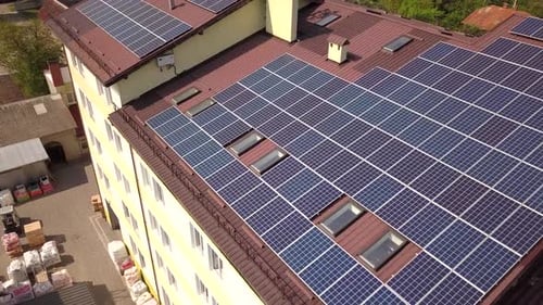 Aerial view of solar panels on the roof of industrial building.