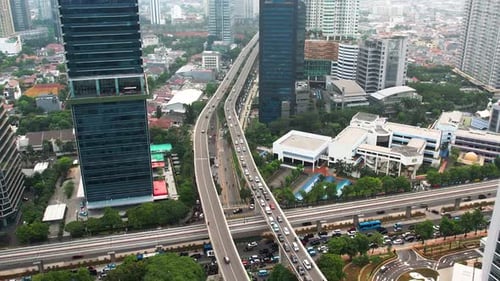 Aerial view of infinity sign traffic junction cross road with car transport. Jakarta, Indonesia
