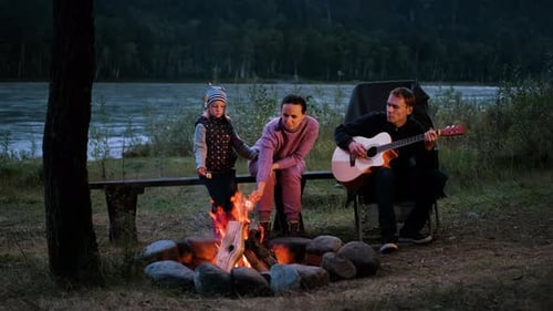 Family Campfire Fun with Guitar at Night
