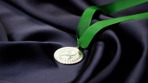 Silver Medal with Green Ribbon on Silk Background