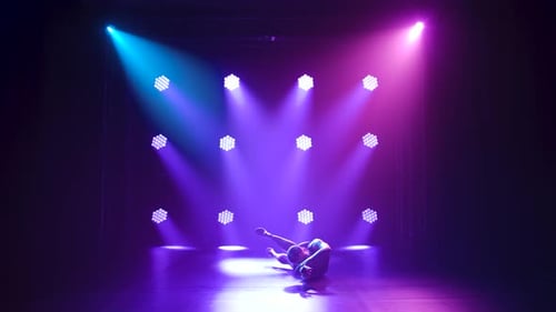 Professional Ballerina in Black Bodysuit Gracefully Dancing Ballet in Dynamic Spotlights and Smoke