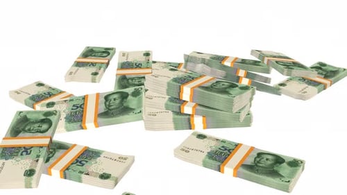 Many wads of money falling on table. 50 Chinese Yuan banknotes.