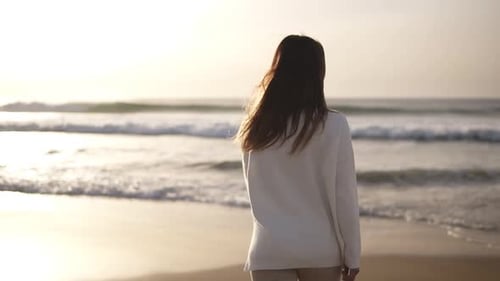 Brunette Woman Walks Alone on Sandy Beach