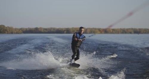Young Man Wakeboarding on River