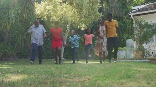 Happy Multi-Generational Family Runs on Lawn