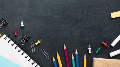 Top view of colorful stationery on blackboard background with copy space