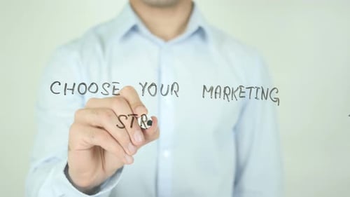 Man Writes Marketing Strategy on Glass
