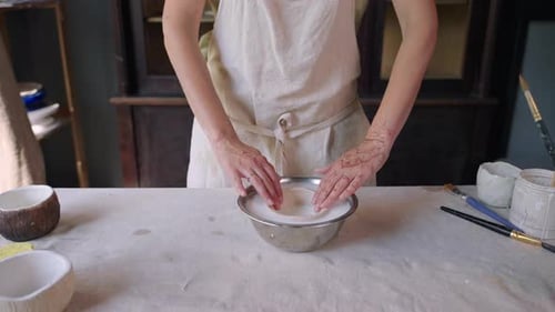Woman Dips Ceramic Bowl into Liquid Glaze