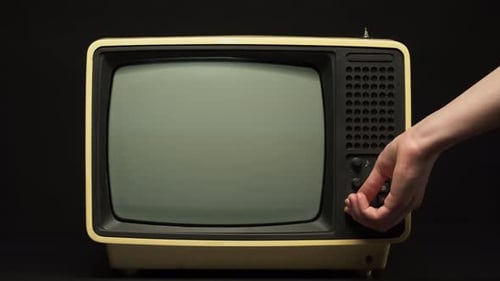 Man Turning on Old Retro Television on Black Background Searching for a Signal Channel Setting