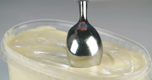 Ice cream scoop scooping mango flavored soft ice cream