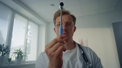 Medical Professional Holding Reflex Hammer in Office