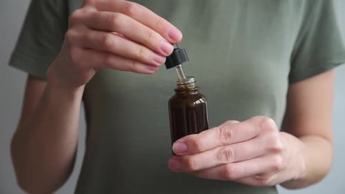 Hands Opening Oil Dropper Bottle