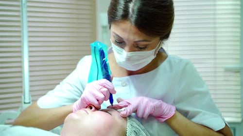 Cosmetologist Applying Permanent Make Up on Eyebrows