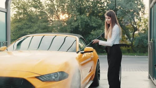 Woman Cleans Yellow Convertible at Carwash