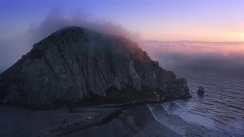 Scenic Rock on Coast Covered By Pink Clouds Golden Sun Shining at Sunset