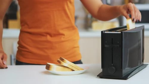 Putting White Bread Slices into a Toaster