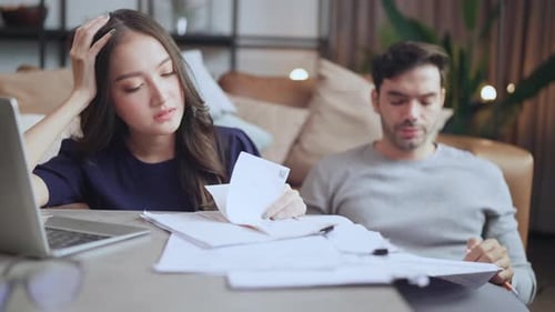 Frustrated Couple Reviewing Bills at Home