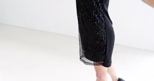 Woman dances in black sequined dress