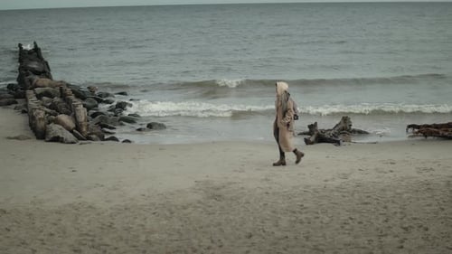 Woman Walking Along The Beach