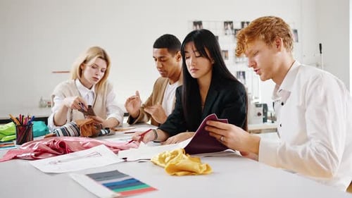 Group of Multiethnic People Choosing Fabric Samples at Fashion Atelier Discussing Fashion Collection