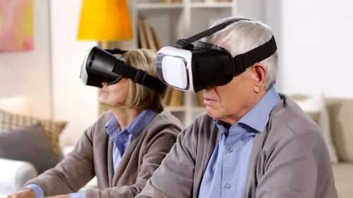 Mature Couple Experiencing Virtual Reality Headsets at Home
