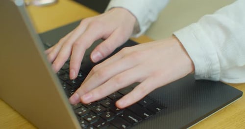 Hände, die auf der Computertastatur tippen, bewegliche Kamera, Geschäftsfrau, die im Büro am Laptop arbeitet.