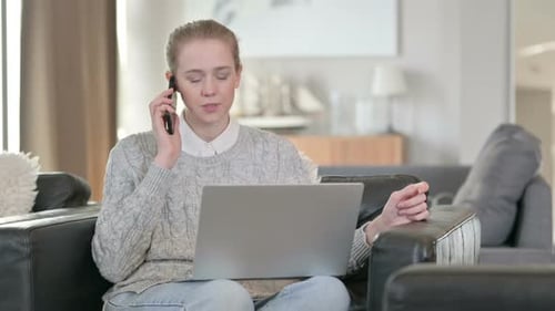Woman Talking on Phone with Laptop