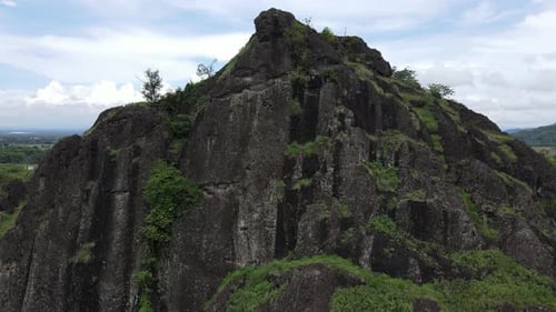 Aerial drone view of rock mountain cliff in the middle of the rice field.