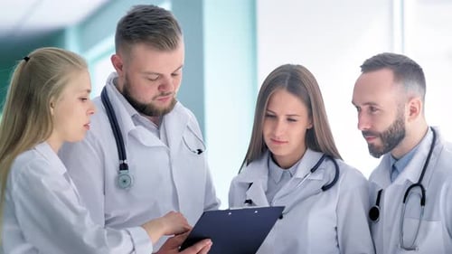 Medical Team Reviewing Documents in Hospital Setting