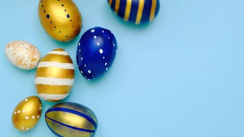 Easter Eggs are Rolling Knocking Each Other on Blue Table