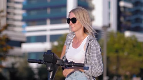 Woman With Electric Scooter in City Environment