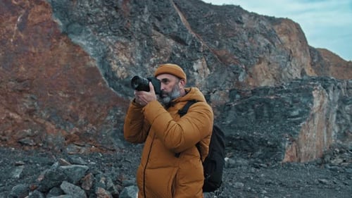 Photographer Taking Photos of Rock Cliff in Wilderness