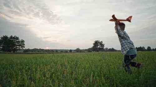 A Boy Launches an Airplane in the Park