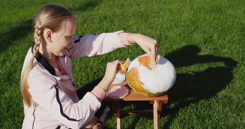 A Girl of 10 Years Old Paints Pumpkins Prepares Jewelry for Helloween