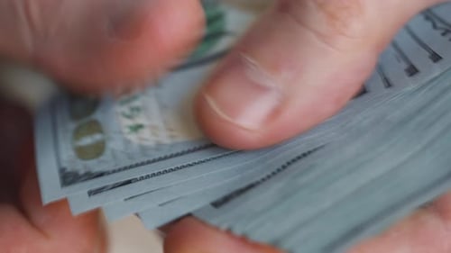 Hands Counting Stack of Dollar Bills Close Up