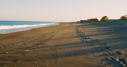 Footprints on the sandy beach at sunset