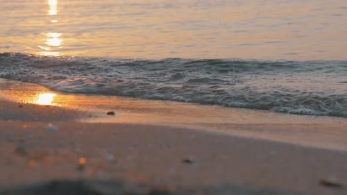 Sea waves rolling on the shore at sunset