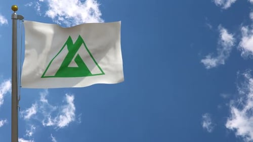 Realistic Waving Flag with Green Abstract Mountain Logo Against Blue Sky