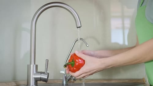 Washing Fresh Red Pepper in Kitchen Sink