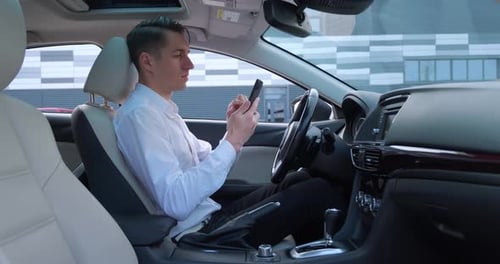 Man in Car Using Smartphone Before Driving