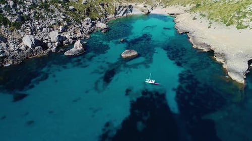 Picturesque Cove With Sailboat on Turquoise Water