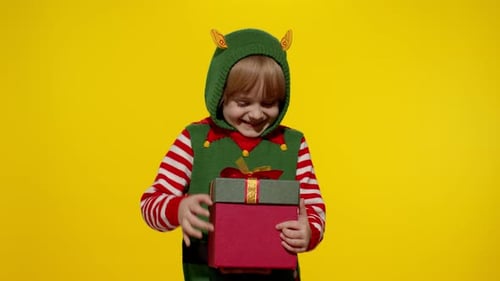 Excited Child in Elf Costume Opens Christmas Gift